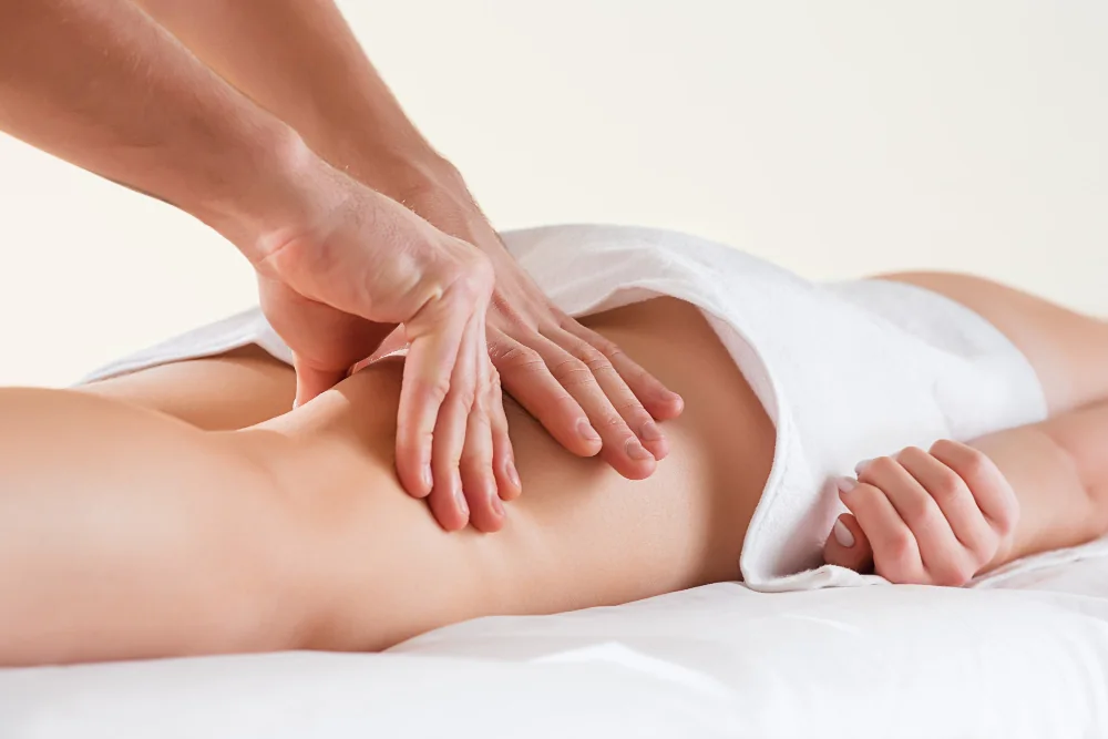 A therapist applying gentle pressure to the calf during a lymphatic massage